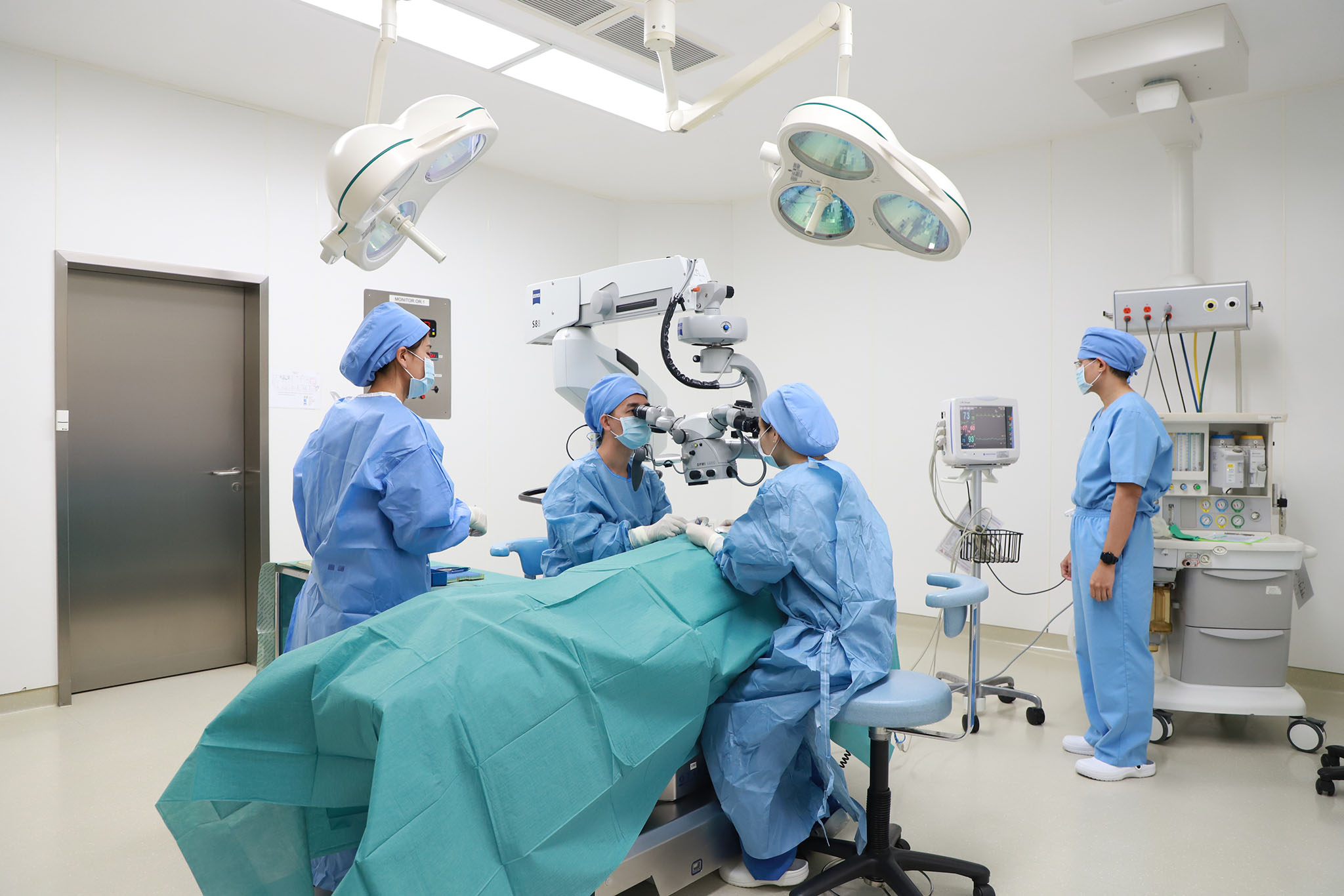 A surgical team operating with a microscope at Kamol Cosmetic Hospital